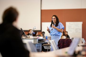 A clinician in scrubs presenting